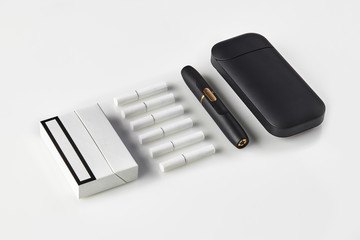 New generation black electronic cigarette and battery, one pack and six heatsticks isolated on...