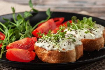 Bruschetta with cheese, salmon and micro-greens on a dish