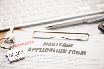 Approved mortgage loan agreement application with house shaped keyring