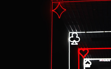 Neon symbol cards suit on black background, emblem and label of gambling games. Playing card. Card games and gambling concept. Night life, poker player. Copy space