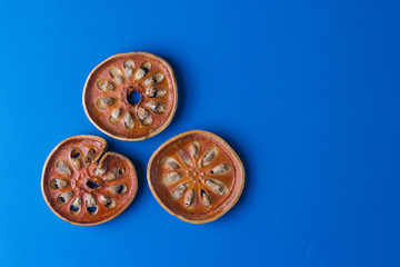 Aegle marmelos. Dry bael fruit on blue background.Top view copy space.