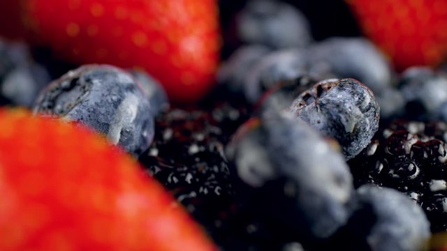 4k dolly macro video of big heap of strawberry, blueberry and blackberry with water droplets. Perfect abstract background for organic food and healthy nutrition.