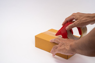 Man hands packing parcel box with tape