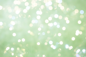 Defocused lights and sparkles on a silver-green background. Festive background concept. Copy space