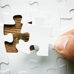 Hand with missing jigsaw puzzle piece. Business concept image for completing the final puzzle piece