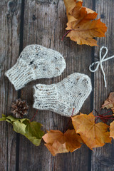 Chunky and warm hand-knitted baby socks on dark wooden background