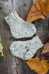 Chunky and warm hand-knitted baby socks on dark wooden background