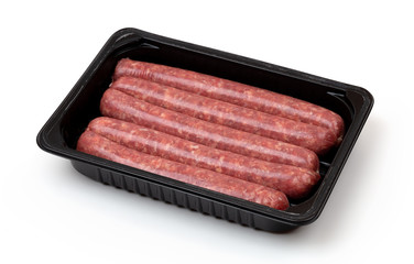 Raw sausages on a white background. Grilled sausages in a plastic container close-up.