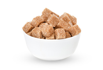 Cane sugar on a white background. Cane sugar cubes in a cup close-up.