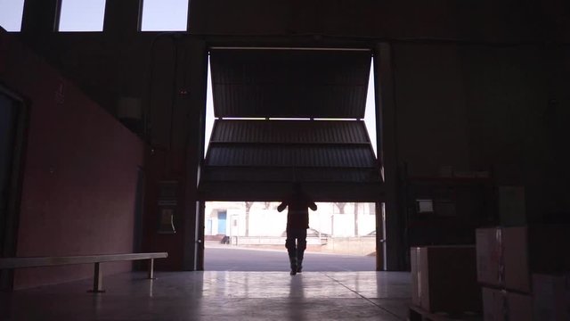 Anonymous worker opening warehouse door