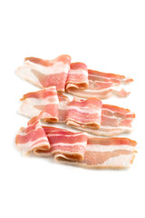 A slice of bacon on a white background. Three raw bacon close up on a white background.