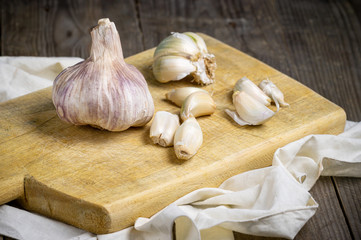 Vintage still life with garlic on wooden table .