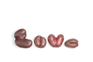  Ugly vegetables. Funny deformed potato in the form similar to letters. Closeup. Copy space