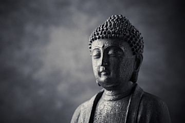 Meditating Buddha Statue on dark background. Copy space