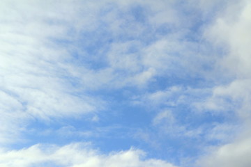 Cloudy blue sky with white and gray clouds. Background for text and design