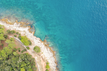 Fototapeta na wymiar The sea surface is turquoise with a small fragment of coastline on the left. The view from the top. Shooting from a drone.