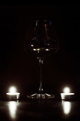 Candles and a glass of wine in the dark.