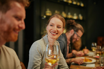 Group of friends sitting in retaurant and eating dinner.