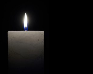 Fototapeta premium Candle flame close-up on a black background.