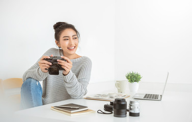 Portrait of beautiful asian photographer woman work office desk hold camera with laptop. Business...