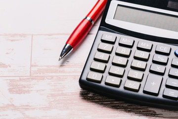 Accounting, financial concept, flat lay, calculator and pen on wooden table