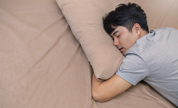 Portrait of young asian man with attractive smile sleeping laying indoor  apartment bed room . Asian man sleep tight in bed with copy space. Healthy  care good night sleep concept Stock Photo |