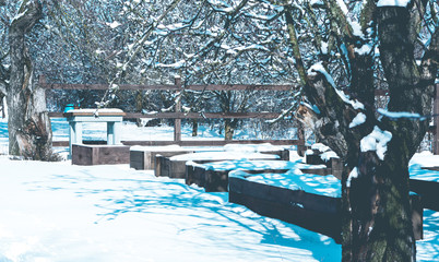 Winter snow-covered garden. Apple trees and wooden vegetables grow boxes with snow.