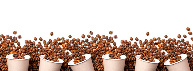 Roasted coffee beans and paper cups on a white background top view, copy space, flat lay, banner. Coffee takeaway concept.