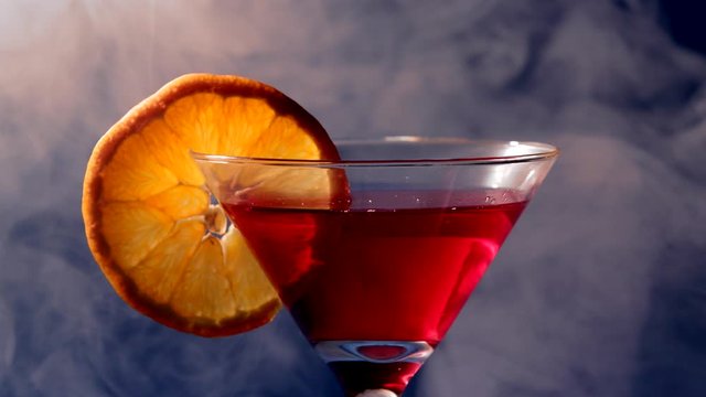Close up of a Fancy Drink with an orange. Smoke in the background