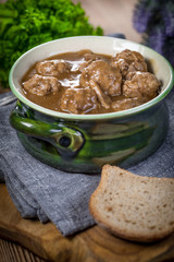 Pork meatballs with noodles in a green bowl.