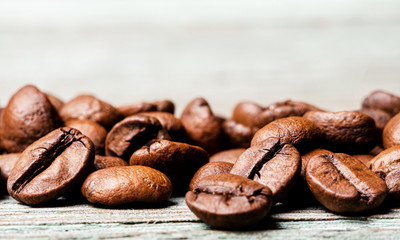 Roasted coffee beans on a wooden background, close-up, copy space.