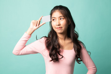 Young Asian woman think with a blank card.