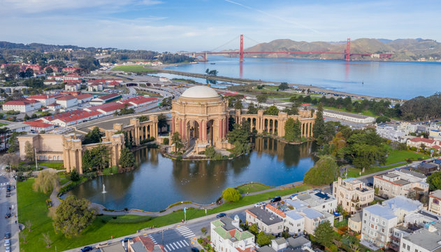 Palace of Fine Arts, San Francisco, California, aerial view with Golden Gate Bridge in the background. Morning light, copy space in sky. Palace reflection in water. Blue sky, red bridge.
