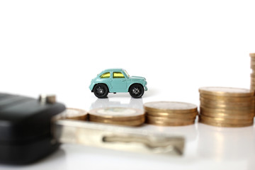Miniature people with coins and car. Miniature businessman walking through a toy car. Concept of...