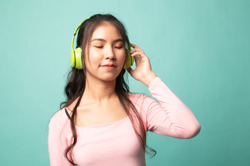 Pretty asian girl listening music with her headphones.