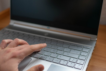 Mano escribiendo en el teclado de un ordenador 