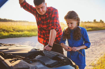 father and daughter fixing problems with car during summer road trip. Kid helping dad.