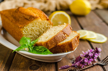 Lemon pound cake on rustic wooden background with lemon.