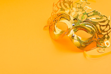 Carnival mask on a yellow background. Decor for a traditional Italian holiday. Copy space. Flat lay