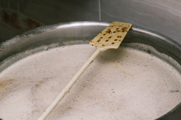 A long plastic stirrer for stirring food in a large pan. Brewing beer. The technology of making...