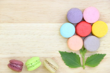 Closeup top view of colorful macarons stack like flower on wood background have copy space. Flat lay style.