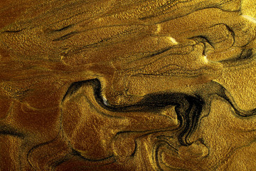 Beautiful stains of liquid nail polish,fluid art technique.Gold marble background.
