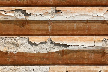 Unusual texture of cracked dilapidated broken striped with horizontal lines old style decorative facade on suburban family house front wall background wallpaper