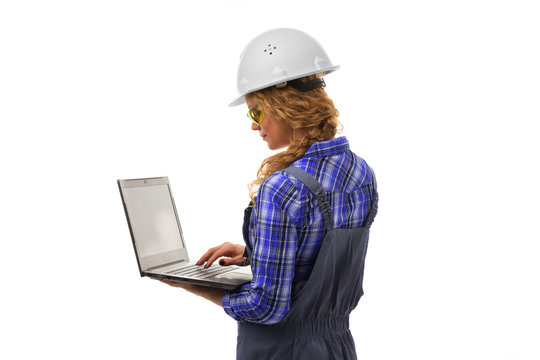 Attractive european female inspection engineer in coveralls, safety white helmet, safety glasses and laptop isolated on white background