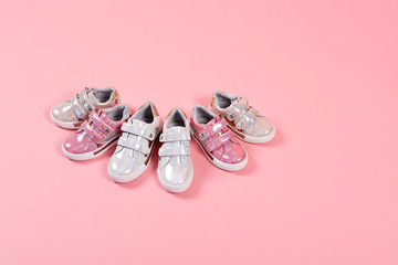 Beautiful baby shoes on a pink background. For children. Stylish pink female shoes on pastel background, copy space. New sneakers on pink background. Beauty and fashion concept. Flat lay, top view.