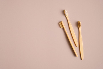 Bamboo wooden toothbrushes on brown background. Eco-friendly, plastic free, zero waste dental tool concept. Flat lay, top view.