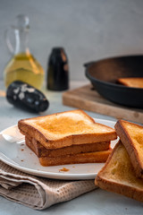 Crispy white bread toasters with butter on a wooden board