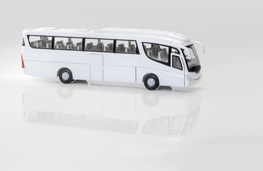autobús de juguete sobre fondo blanco con reflejo