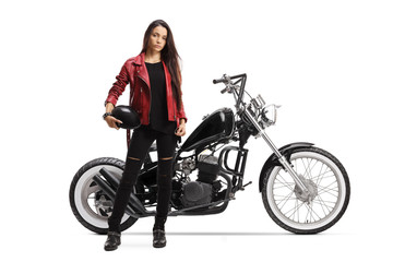 Fototapeta na wymiar Young woman holding a helmet and standing next to a custom motorcycle