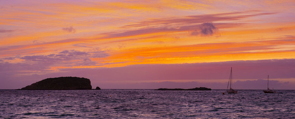 Sunrise with red sky on the beach of Es Canar, Ibiza Island, Spain